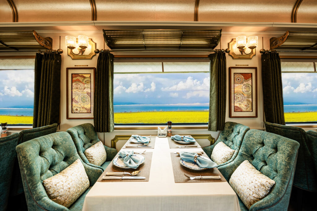 White dining table with velvet mint chairs on the Golden Eagle Silk Road Express train.