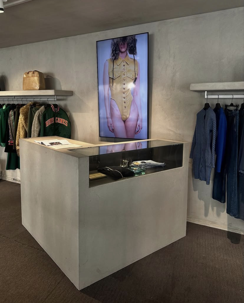 A concrete accessories display counter in the middle of a fashion boutique shop.
