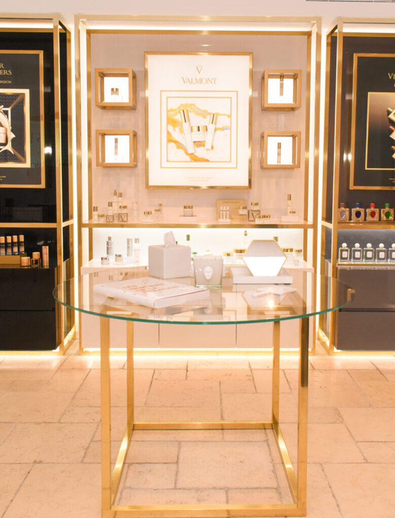 Luxury skincare and beauty items placed on a decorative table and modern shelves.